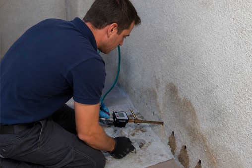 Homme qui applique traitement contre mur humide